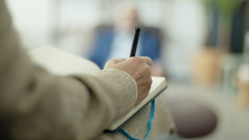 Psicólogo tomando notas en tratamiento psicológico para la depresión