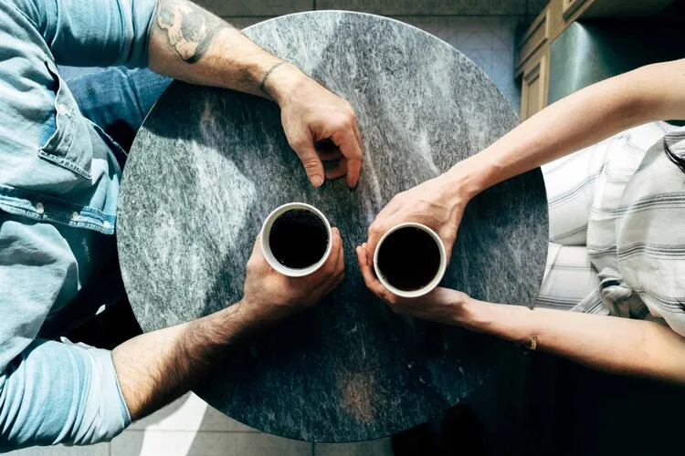 Una pareja tomando café, representando el diálogo en una psicoterapia o terapia online de pareja